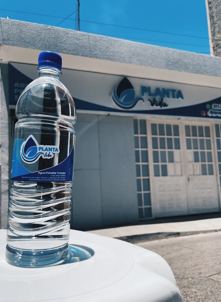 Botella de agua potable tratada Planta Vida frente a la sede